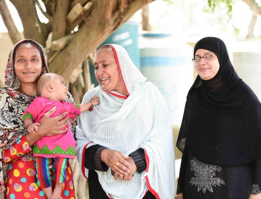 Kausar and her daughter with Lady Health Worker Sehat Panwar and Saiqa Moosa, a skilled birth attendant, outside Mithani RHC